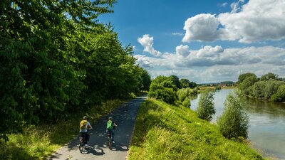 Pärchen fährt mit dem Fahrrad entlang der Weser