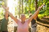 Frau beim Waldbaden blickt in die Sonne